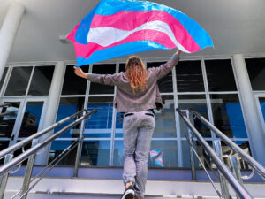 Marquita segurando a bandeira trans, símbolo que representa a comunidade transgênero. Foto: Heloisa Helena